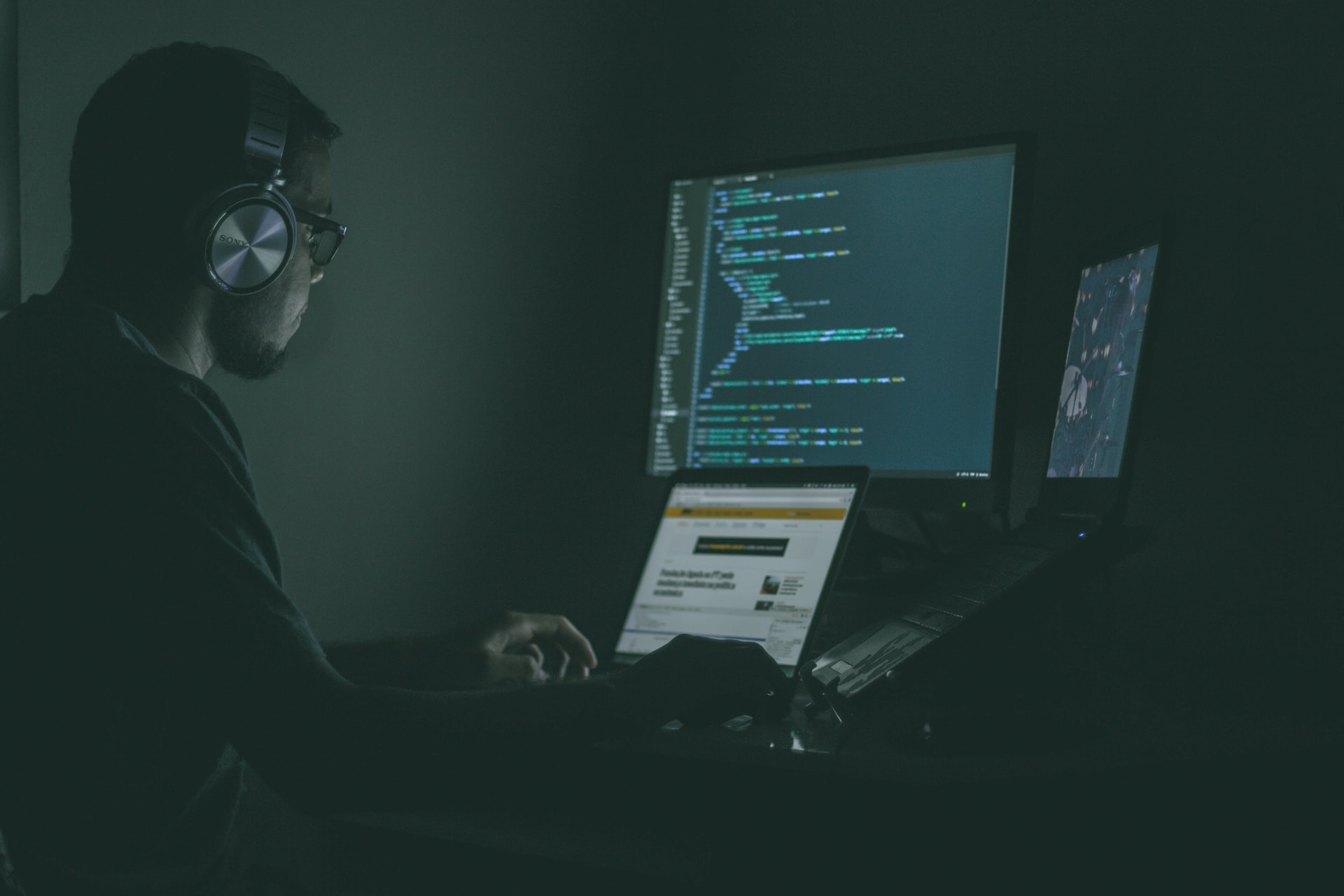 a person writing code in a dark room